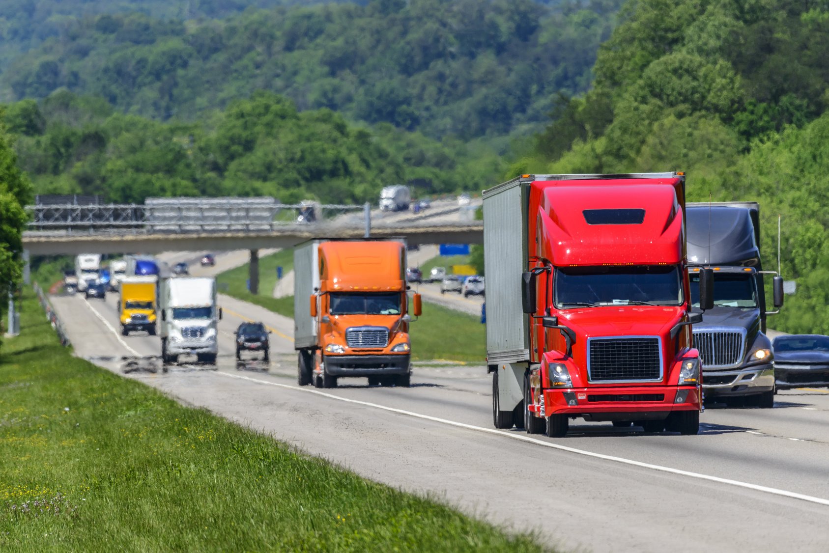 Series of semi trucks driving down the highway using green diesel fuels